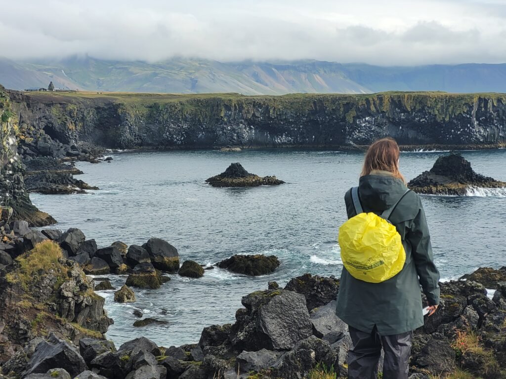 Girl looking at Arnastapi Coastline, Iceland